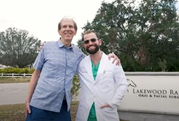 Dr. Austin L. Lyman  posing with female patient outdoors near Lakewood Ranch Oral & Facial Surgery sign