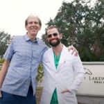 Dr. Austin L. Lyman  posing with female patient outdoors near Lakewood Ranch Oral & Facial Surgery sign