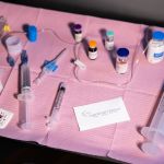 Sterile medical tray with syringes, medication vials, IV supplies, and anesthesia equipment