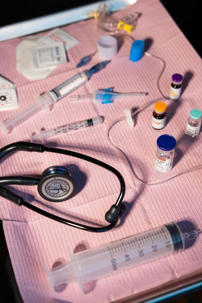 Sterile medical tray with syringes, medication vials, IV supplies, and anesthesia equipment